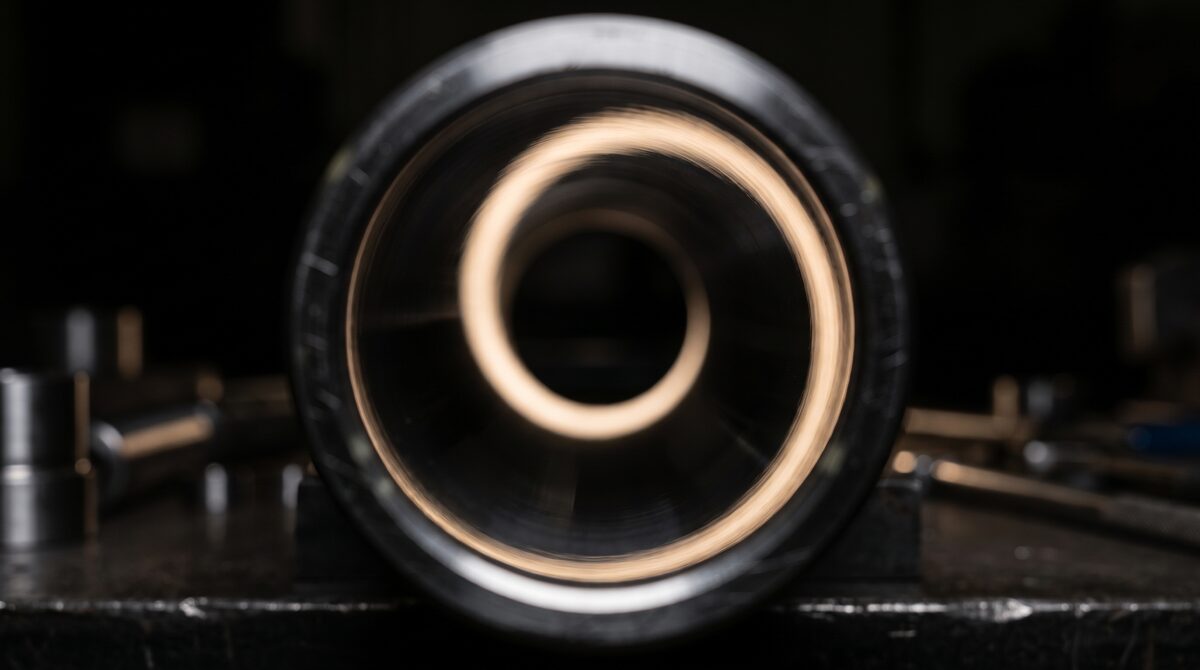 Extreme macro looking into the open end of a finished cylinder tube, the inside wall polished to a mirror and reflecting...